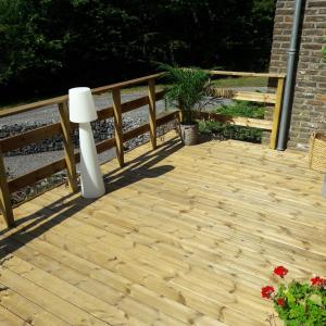 una terraza de madera con una valla y una planta en Gîte d'Anthisnes en Anthisnes