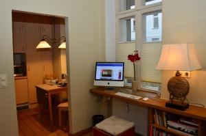 a computer on a desk with a lamp and a window at Zentral gelegen - stilvolles Appartment in Moabit in Berlin