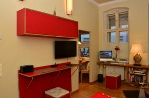 ein Wohnzimmer mit einem roten Schreibtisch und einem Computer in der Unterkunft Zentral gelegen - stilvolles Appartment in Moabit in Berlin