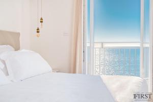 a bedroom with a white bed and a large window at Il Sogno di Manarola by The First in Manarola