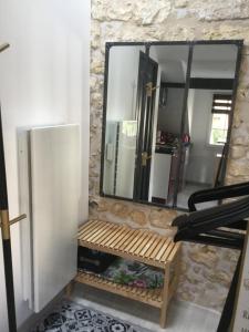 a bathroom with a mirror and a wooden bench at Studio centre ville in Compiègne