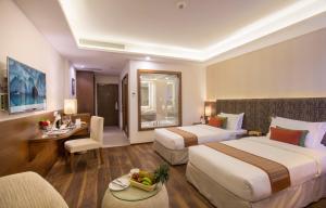 una camera d'albergo con due letti, un tavolo e delle sedie di Mountain Glory Forest Resort a Pokhara