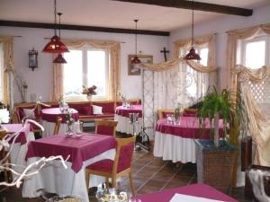 um restaurante com mesas cor-de-rosa, cadeiras e janelas em Wellnesshotel Legde em Legde