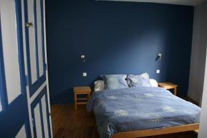 a blue bedroom with a bed and a blue wall at Maison Fouga in Cadéac