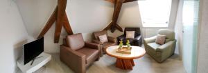 a living room with two chairs and a television at Monteurzimmer Ferienwohnungen Fritsche-Bad Mergentheim in Bad Mergentheim