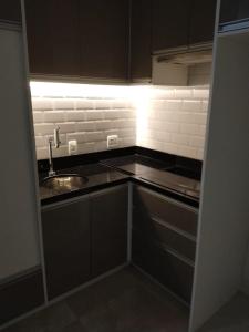 a kitchen with black cabinets and a sink at PLAZA DE LA REPUBLICA CON GARAGE in Sao Paulo +46 photos
