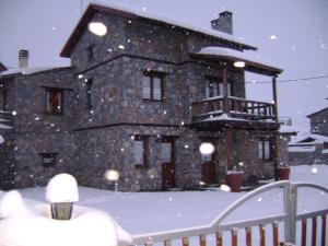 a large stone building with snow on it at Villa Monte Nord in Palaios Agios Athanasios