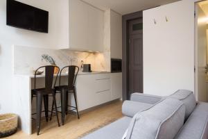 ein Wohnzimmer mit einem Sofa, einem Tisch und Stühlen in der Unterkunft Oporto Sweet Home III in Porto