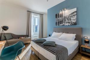 a bedroom with blue walls and a bed and a couch at OTTO Rooms & Photogallery in Rome