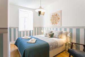 リスボンにある2 beautiful suites upscale flat embracing Tejo!のベッドルーム1室(青と白のストライプのベッド1台付)