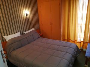 una camera da letto con un letto e una finestra di Hotel Restaurant L'AGAPANTHE a Pont-de-Salars