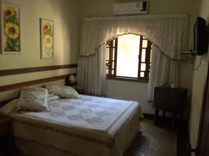 1 dormitorio con cama y ventana en Pousada Praia de Itacoatiara en Niterói