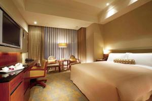 a hotel room with a large bed and a desk at San Want Residences Taipei in Taipei