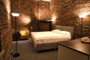a bedroom with a bed and a brick wall at Stawowa 13 in Katowice