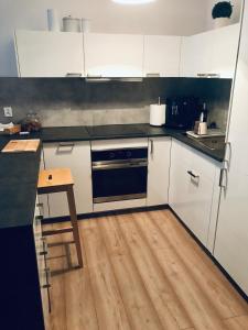 cocina con armarios blancos y suelo de madera en OMI Apartments, en Kołobrzeg