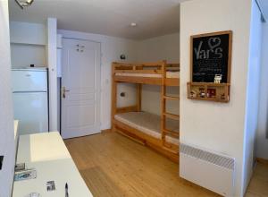 ヴァールにあるBoost Your Immo les lofts de Vars 80の二段ベッド1組、冷蔵庫が備わる小さな客室です。