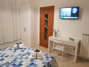 a room with two beds and a desk and a tv on the wall at Barone Blu in Salerno