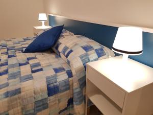 a bedroom with a bed and a nightstand and lamps at Barone Blu in Salerno