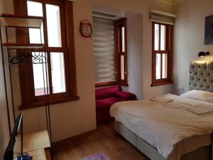 a bedroom with a bed and a red chair at Linden Houses in Istanbul