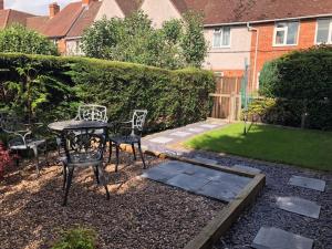 um pátio com uma mesa e cadeiras num quintal em Comfortable House in Warwick em Warwick