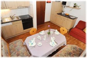 une table dans une cuisine avec un chiffon de table blanc dans l'établissement Appartment Valnova / Barga, à Partenen