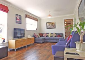 a living room with a blue couch and a tv at The Dairy House in Gosport