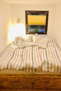 ツィングストにあるlittle Roséの窓、ストライプ掛け布団付きのベッド
