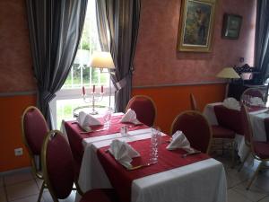 a dining room with two tables and a window at L'Abribis in Firminy