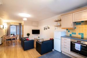 eine Küche und ein Wohnzimmer mit einem Sofa und einem Tisch in der Unterkunft Spacious 2BR Flat in Stansted in Stansted Mountfitchet