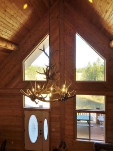 una lámpara de araña en una cabaña de madera con ventanas en The Hideaway Lodge, en Island Park