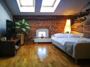 een slaapkamer met een bed en een bakstenen muur bij Designer Apt in the heart of Kraków 4th floor no lift in Krakau