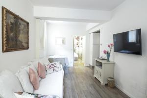 een woonkamer met een witte bank en een flatscreen-tv bij Charming and cosy apartment in Bologna