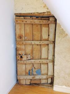 a wooden door in the corner of a room at Le Manoir des Doyens Loft - Sleeps 8 - D-Day Museum on-site - Ten Minute Walk to Commonwealth Cemetery! in Bayeux