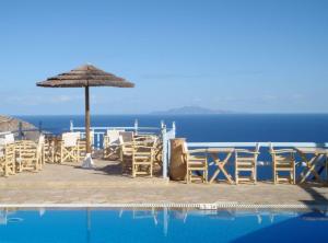 a group of chairs and an umbrella next to a pool at Fata Morgana in Chora Folegandros