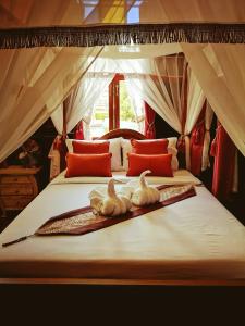 two swans sitting on top of a bed at Baan Sithepaban Guesthouse in Phitsanulok +197 photos