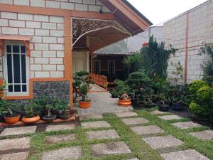 a patio with potted plants in front of a house at Villa Daffa Ciwidey in Ciwidey