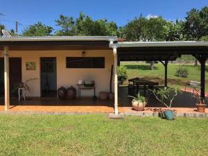 a house with a patio and a table in front of it at Villa Vivi in Gros-Morne