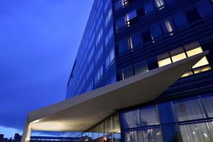 a tall glass building with a blue sky at UNAHOTELS San Vitale Bologna in Bologna