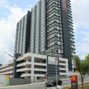 een hoog gebouw met een bord ervoor bij Galleria Equine Park in Seri Kembangan