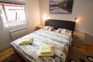 een slaapkamer met een bed met gele handdoeken erop bij Rooms Sejo in Kolašin