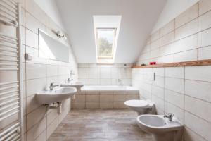 baño con 2 lavabos, bañera y 2 aseos en Pivovar a Penzion GRASEL en Český Rudolec