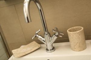 - un lavabo avec robinet et un rouleau de papier toilette dans l'établissement Apartment Grepon 2, à Chamonix-Mont-Blanc