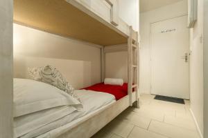 - une chambre avec des lits superposés et une couverture rouge dans l'établissement Apartment Grepon 2, à Chamonix-Mont-Blanc