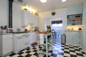 a kitchen with white cabinets and a checkered floor at Retro Bungalow in Santa Rosa