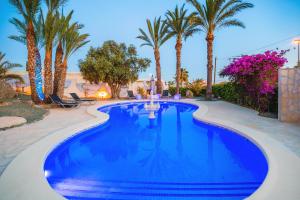 - une piscine avec des palmiers dans un complexe dans l'établissement Casa Almendros, à Ciudad Quesada