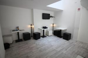 Cette chambre comprend 2 bureaux, 2 tables et une télévision. dans l'établissement New Generation Hostel Milan Center, à Milan
