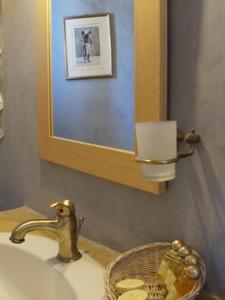 a bathroom with a sink with a mirror and a basket at Fata Morgana in Chora Folegandros +31 photos