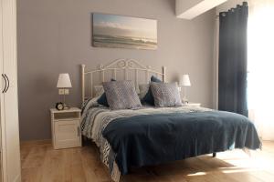 a bedroom with a bed with blue sheets and pillows at La Posada de Mijas in Mijas