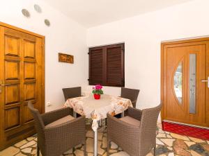 einen Tisch mit Stühlen und eine Vase mit Blumen darauf in der Unterkunft Apartments Nives in Poreč