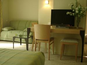 a living room with a desk with a computer and a couch at Hôtel Les Esclargies in Rocamadour